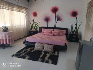 Un dormitorio con una cama rosa con almohadas rosas y flores en Casa Campo Emaus en Caucasia