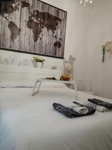 białe łóżko ze stołem i 2 ręcznikami w obiekcie La luminaria w mieście Bari