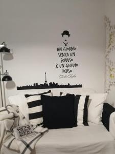 salon z białą kanapą i słowami na ścianie w obiekcie La luminaria w mieście Bari