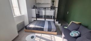 a small bedroom with a bed and a couch at STUDIO Dole Grevy deux étoiles, in Dole