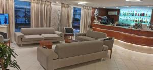 uma sala de espera com dois sofás e um bar em Hotel Sandra em Rimini