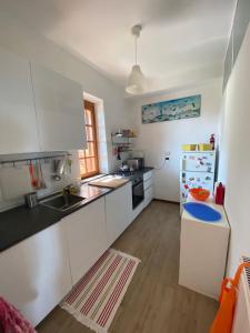 a kitchen with white cabinets and a refrigerator at Via dei Ginepri in Noli