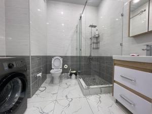 uma casa de banho com um WC e uma cabina de duche em vidro. em Караван Сарай 3 em Türkistan