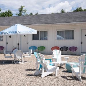 a group of chairs and an umbrella in front of a building at Motel Chelsea in Chelsea