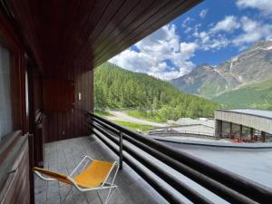 a chair on a balcony with a view of mountains at Appartamento I Dadi Cervinia in Breuil-Cervinia