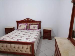 ein Schlafzimmer mit einem Bett mit rosa Kissen darauf in der Unterkunft Maison a louer à kelibia in Kelibia