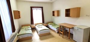um quarto com três camas e uma mesa e uma janela em Sio Hostel em Siófok