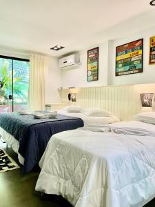 a bedroom with two beds and a window at Pousada Canto da Vigia in Penha