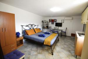 a bedroom with a bed and a table and a kitchen at L' Arca Residence in Cefalù