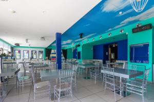 un restaurante con paredes azules, mesas y sillas en Hotel Spicy, en Sorrento