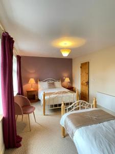 a hotel room with two beds and a window at Deerbrook House B&B in Cahir