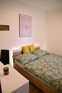 een slaapkamer met een bed met gele kussens en een tafel bij Apartment with a sun terrace,privat parking in Banská Bystrica