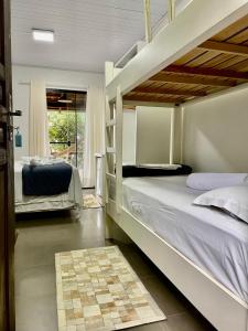 a bedroom with two bunk beds and a balcony at Pousada Canto da Vigia in Penha