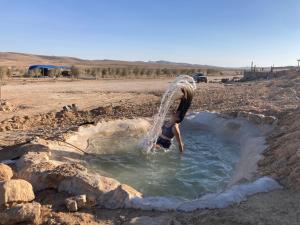 a person is standing in a pool of water at Skyline eco-camp in Mitzpe Ramon