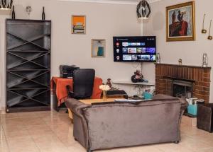 a living room with a couch and a fireplace at Birdville BNB Guest House in Gaborone