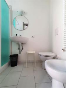 ein Badezimmer mit einem Waschbecken, einem WC und einem Spiegel in der Unterkunft Affittacamere Casa Cynda in Follonica