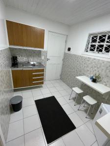 een keuken met een wastafel en een tafel en stoelen bij Kitnets da Lane in Campos do Jordão