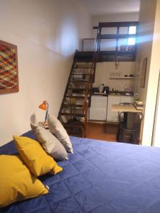a bedroom with a bed with pillows and a staircase at Azules de Abril in Yerba Buena