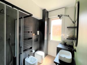 y baño con aseo, lavabo y ducha. en Alfea Suite en Bolonia