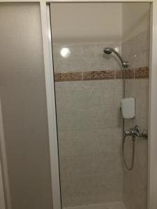 a shower with a glass door in a bathroom at Penzion Xaver in Blučina