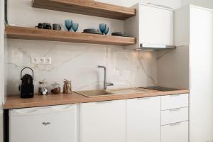 a kitchen with white cabinets and a sink at Amalia in Matala
