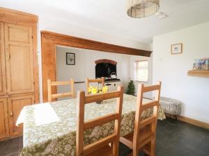 a dining room with a table and chairs and a fireplace at Hops Cottage in Ashbourne