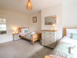 a bedroom with two beds and a mirror at Hops Cottage in Ashbourne