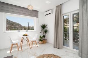 a dining room with a table and chairs and a window at Amalia in Matala