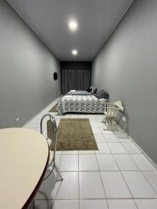 a bedroom with a bed and a table and chairs at Kitnets da Lane in Campos do Jordão