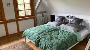 a bedroom with a green comforter on a bed at Ferienwohnung am Schlossgarten in Schmieheim