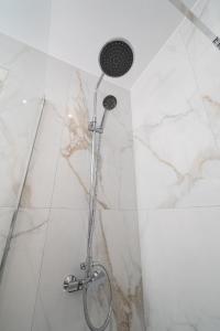 a shower in a bathroom with white marble at Amalia in Matala