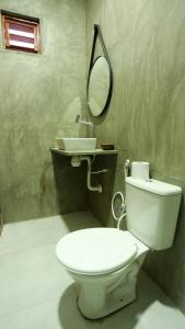 uma casa de banho com um WC branco e um lavatório. em Pousada Movimento em Praia do Preá