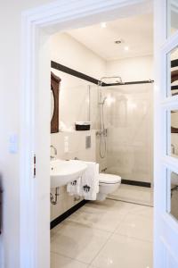 a white bathroom with a sink and a toilet at Prohipo Stables & LMC - Premium Rooms 