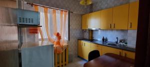 uma cozinha com armários amarelos e um lavatório em Central Residence em Ploiesti