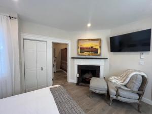 1 dormitorio con chimenea y TV en la pared en The Reminisce vacation home 5br/3bt,downtown BH, en Bar Harbor