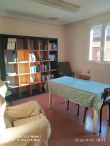 um quarto com uma mesa e uma estante de livros em Albergue La Esperanza de la Sagrada Familia em Melgar de Fernamental