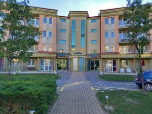 un gran edificio de apartamentos con entrada de ladrillo en Karos Gold 813 Wellness Apartman, en Zalakaros