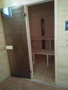 a large wooden sauna with a glass door at Kiserdő Vendégház in Rajka