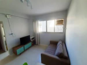 ein Wohnzimmer mit einem Sofa und einem TV in der Unterkunft Leblon Central in Rio de Janeiro