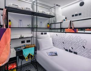 a room with a large white bed and shelves at WOM Beach Pod Hotel - a member of Brown Hotels in Tel Aviv