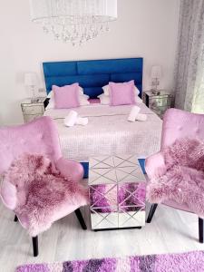 een slaapkamer met een bed met roze stoelen en een tafel bij Downtown luxury apartment Emili in Split