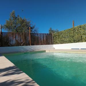 una piscina de agua verde junto a una valla en Casa do Sossego, en Igrejinha