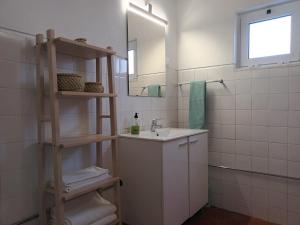 baño con lavabo, espejo y estante en Casa do Sossego, en Igrejinha