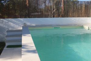 a swimming pool with blue water next to a fence at Casa do Sossego in Igrejinha