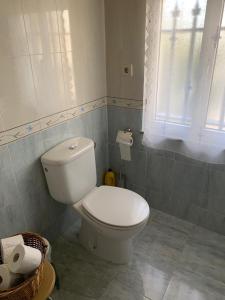 a bathroom with a white toilet and a window at Casa ferreiro in Ribadeo