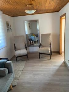 uma sala de estar com duas cadeiras e um sofá em Casa ferreiro em Ribadeo