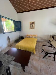 a bedroom with a bed and a table and chairs at Chalés de Triunfo in Triunfo