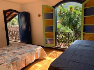 1 dormitorio con cama y ventana grande en Ubatuba _ Vivencie nossa energia en Ubatuba