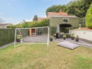 a backyard with a soccer net in the grass at Hallstead in Skegness