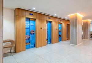 a row of elevators in a building with blue signs at B&B HOTEL Rio Copacabana Posto 5 in Rio de Janeiro